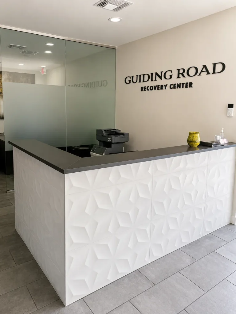 Reception desk with the Guiding Road Recovery Center sign