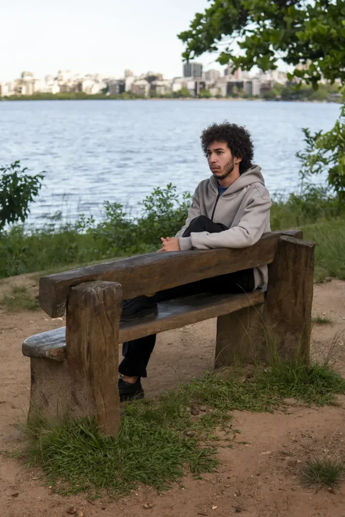 Man sitting quietly by water during co-occurring disorder treatment at Guiding Road