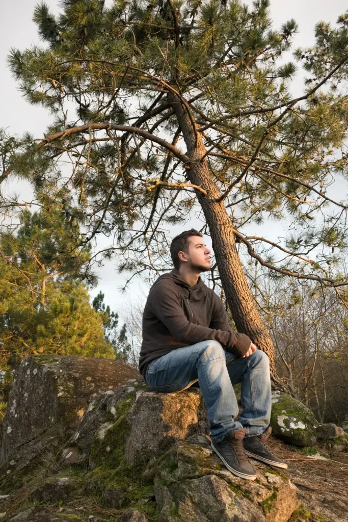 Man sitting outdoors reflecting during addiction treatment at Guiding Road