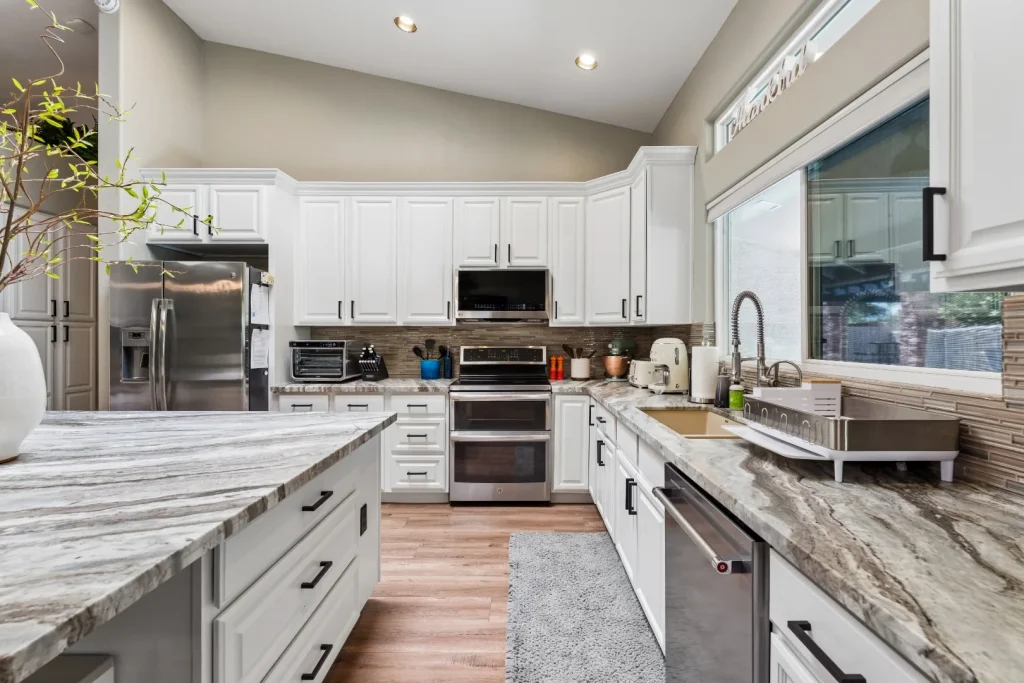 Kitchen with marble countertops and white cabinets