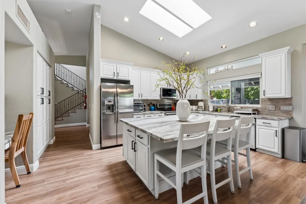 Kitchen island with bar stools and white cabinets