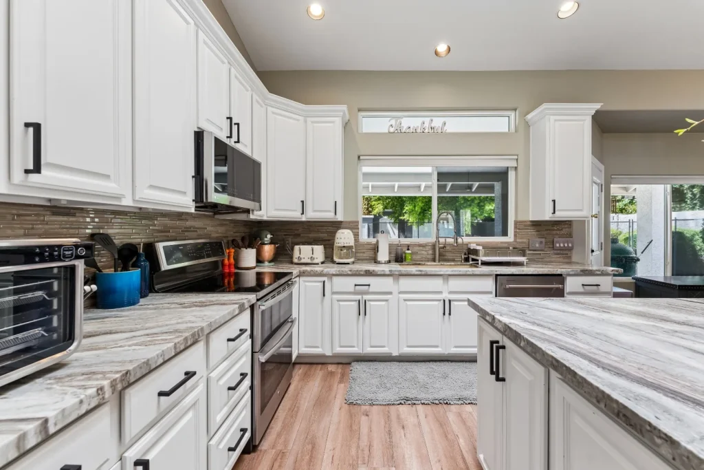 Kitchen with white cabinets and a window above the sink