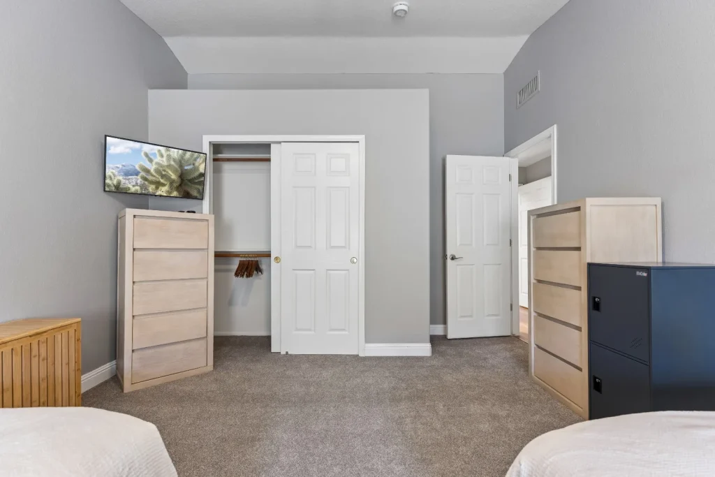 Bedroom with a dresser, closet, and television